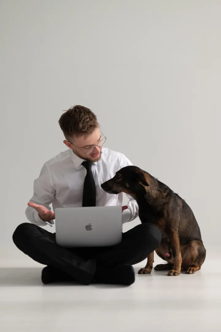 Dmytro Kolida discusses code with a dog beside a laptop